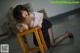 A woman sitting on top of a wooden chair.