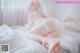 A woman in a wedding dress laying on a bed.