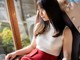 A woman sitting on a chair looking out a window.