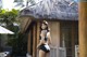 A woman in a black bathing suit standing in front of a hut.