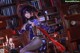 A woman in a witch costume sitting on a chair in front of a bookshelf.