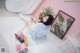 A woman laying on a bed next to a plant.